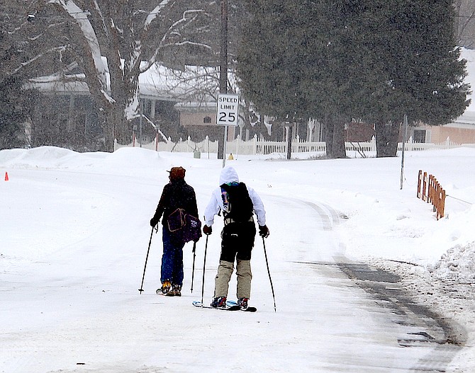 Two skiers make their way down Main Street in Genoa on Tuesday morning.