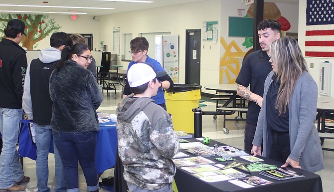 Representatives from Western Nevada College, left, and Truckee Meadows Community College discuss their programs with Churchill County High School students and their parents.