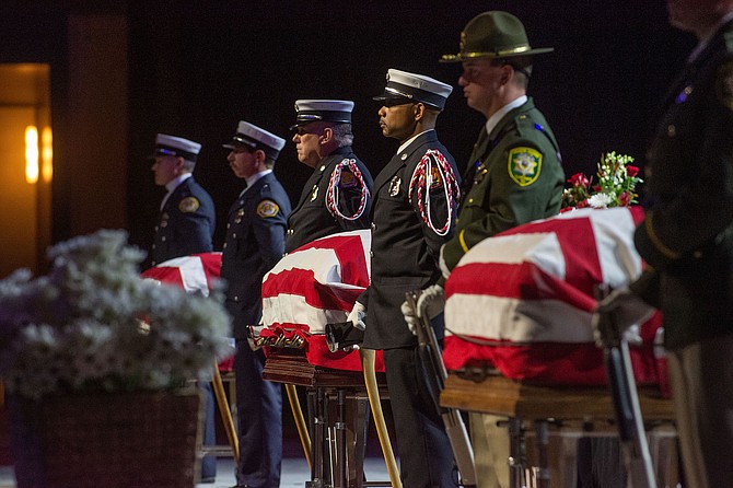 An honor guard with the caskets of three crew members killed in the crash of a medical transport plane near Stagecoach on Feb. 24.