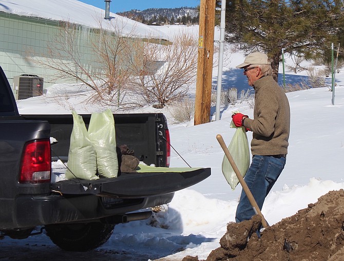 Alpine View resident Brian Shaw carries a sand bag to his truck in preparation for possible flooding.
