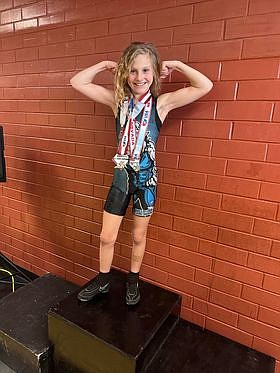 Leah McBroom flexes with her state championship medals after winning the title in the girls 10U folkstyle this past weekend in Las Vegas. McBroom went 3-0 with three pins en route to winning the 58 to 61 pound bracket.