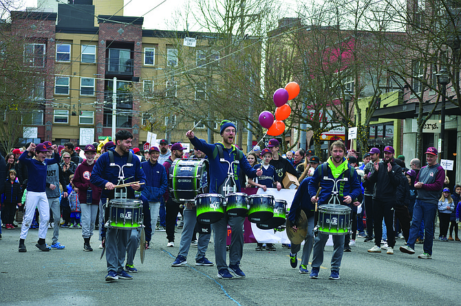 Queen Anne Little League players march down the Avenue, accompanied by Seahawks Blue Thunder Drumline, as League President Tommy Kim and KUOW’s Kirsten Kendrick provide commentary from their lookout at Bethany Presbyterian Church.