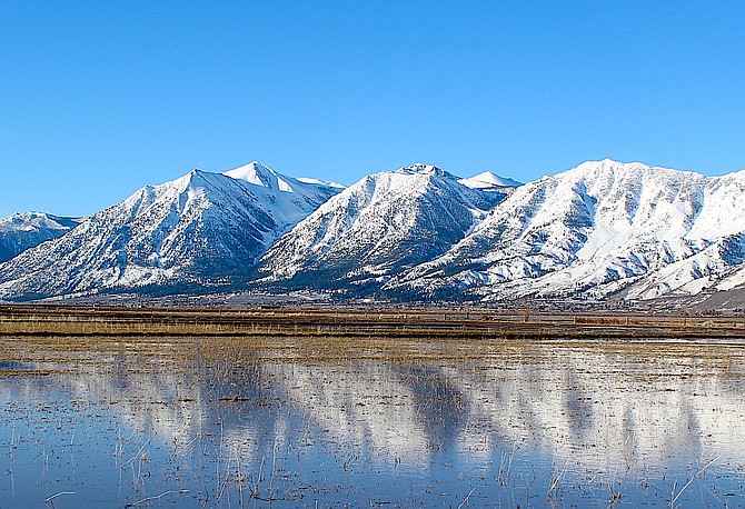 The Carson Range is reflected in a flooded field south of Genoa Lane on Wednesday morning.