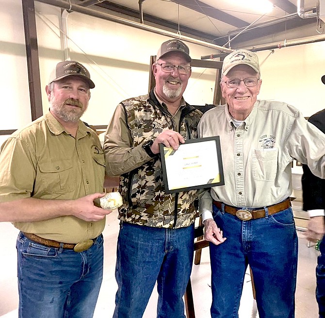 Todd Wilcks and John Hillenbrand present the 2nd Carson Valley Chukar Club award to Dave Sharp with a certificate and a Silver Chukar engraved Belt Buckle.