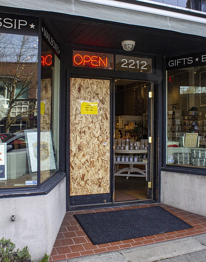 One side of the front door of Queen Anne Dispatch is boarded to keep out intruders after a break-in late last year. Crime in the Upper Queen Anne business district has taken its toll on business owners, with few quick solutions available.