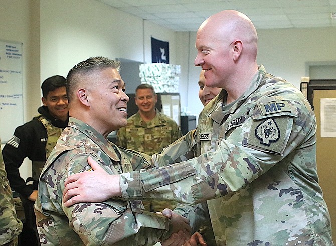 State Command Sgt. Major Dennis Basilio, left, congratulates Sgt. 1st Class Dan Rogers, first sergeant for the 137th Military Police Det., for a job well done. A Nevada group led by Maj. Gen. Ondra Berry, the adjutant general, visited the MPs in late January.