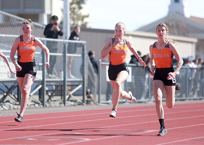 A trio of Douglas High sprinters run the 100-meter dash Wednesday afternoon at the Tigers’ home track meet. Pictured, from left, are Logan Karwoski, Elizabeth Gneiting and Grace Strabala. All three set personal records for the season in the event.
