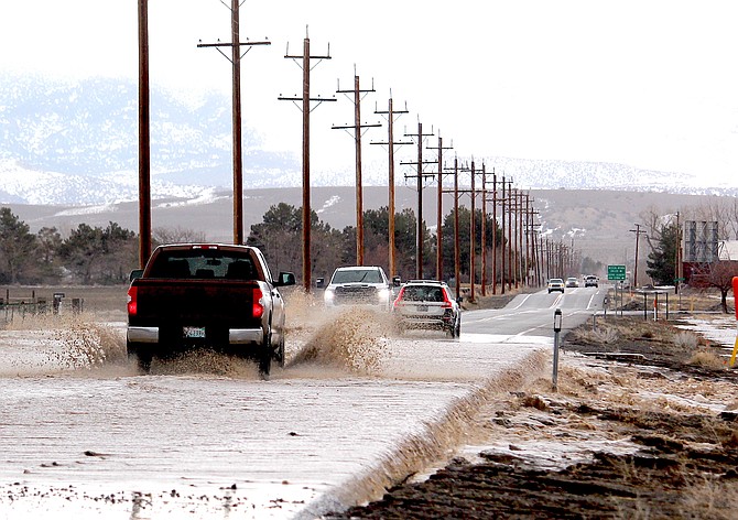 Vehicles splash through water crossing Buckeye Road on the morning of March 10. Two days later the county issued a cautionary alert about the Dangberg Reservoir.