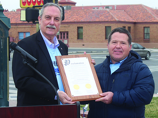 Mayor Ken Tedford, left, presents the proclamation on 'Child Abuse Prevention Month' to County Commissioner Dr. Justin Heath.