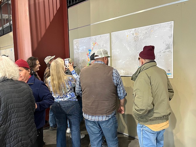 Residents look at Carson River flow charts at a town hall meeting Thursday.