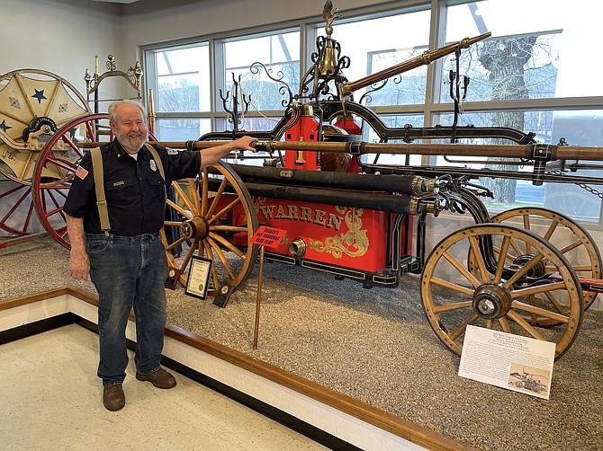 Warren Engine Co. No. 1 Trustee Paul Webster in front of an 1847 handpump fire engine in the company’s museum on April 17.