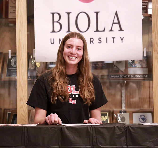Camden Miller smiles after signing her National Letter of Intent to play basketball next winter at Biola University in La Mirada, Calif.