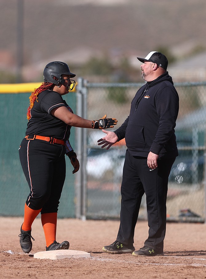 Douglas High’s Lilyann Lee, left, high-fives Tiger assistant coach Matt Tretton during a game last week against Damonte Ranch. Lee homered in the first game against Reno this weekend.