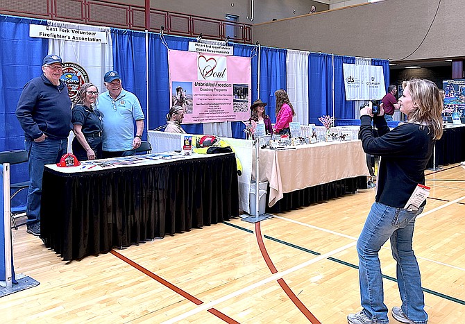Chamber of Commerce Executive Assistant Mikey Andersen takes a picture of folks at the East Fork Fire District Volunteer Association booth on Thursday.