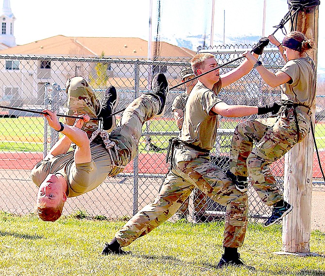 Douglas High Jr. ROTC cadets Lt. Col. Sean Upshaw (on the rope), 1st Sgt. Ian McDonald, and Staff Sgt. Harley Smith. Watching from behind the fence is Sgt. Aaron Greenwood.