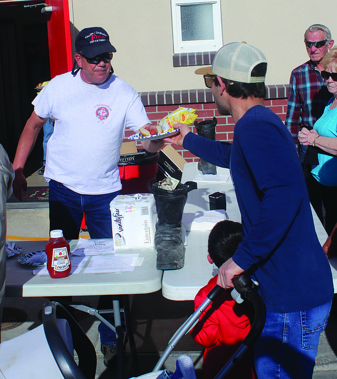 Firefighter Mike Compagnoni serves a meal at last year’s street dance and dinner.