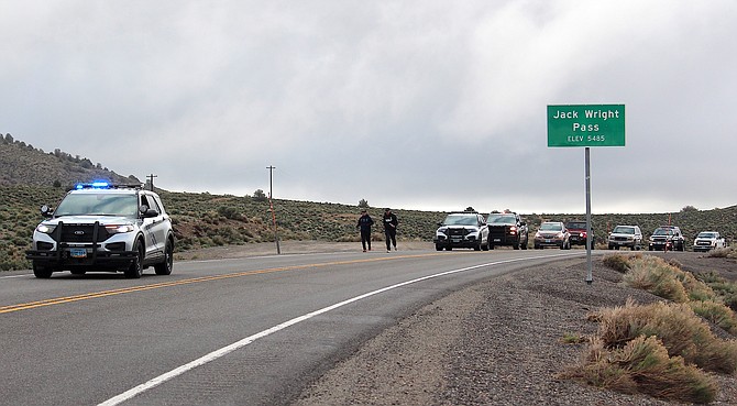Douglas County deputies run along Highway 208 at Jack Wright Pass this morning.