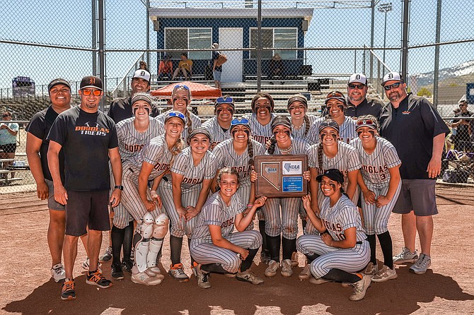 The entire Douglas High softball team poses for a photo at home plate with the Class 5A North regional championship trophy. The Tigers won their second consecutive regional championship Saturday at Carson High School.