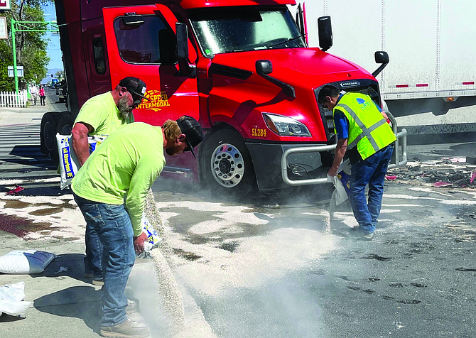 A city of Fallon crew cleans oil and gas on Williams Avenue after a crash Friday afternoon between an SUV and semi-trailer truck.