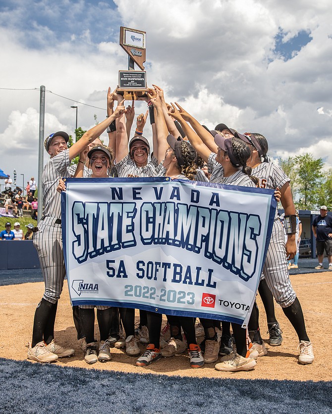 The Douglas High School softball team holds up the championship trophy and banner after winning the Class 5A state title Saturday over Centennial, 6-4.