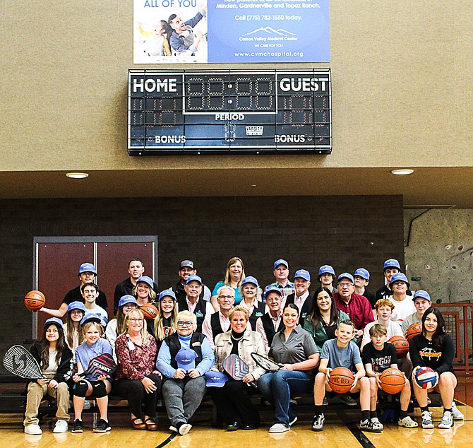 Members of the Community Services Foundation and players celebrate sponsorship of the scoreboard at the Douglas County Community and Senior Center gym.