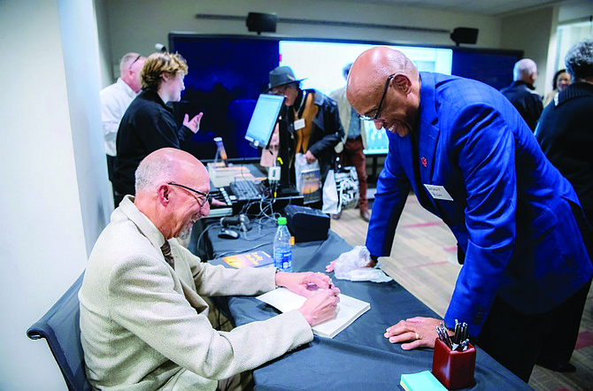 Magnolia resident and retired urologist Lester Thompson signs a copy of his book ‘Lucky Medicine: A Memoir of Success Beyond Segregation’ at a book signing earlier this year hosted by his medical school alma mater, Indiana University School of Medicine.