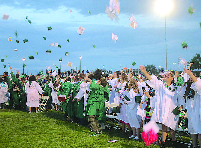 Seniors throw their caps in the air after graduation.