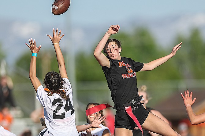 A Douglas High School junior, in the white jersey, reaches for the ball at Friday night's Mountain Madness Powder Puff football game.