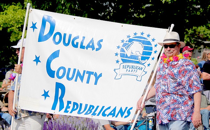 Douglas County Republican Party Chairman Jim McKalip holds his side of the banner for the Carson Valley Days Parade best political float.