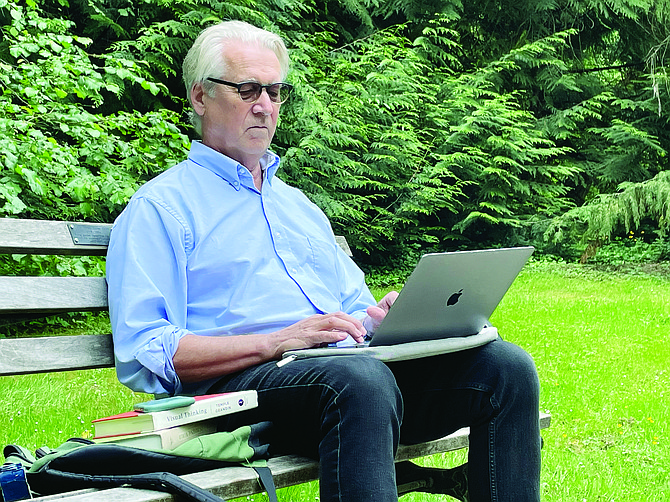 Madison Park resident and new author Peter O’Neil sits in front of his computer in Madison Park recently.