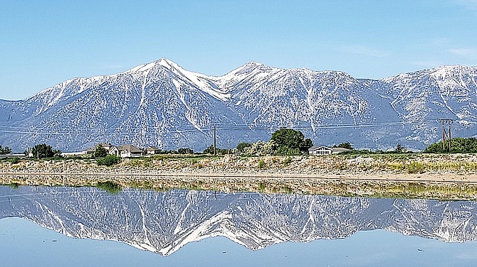 The Carson Range is reflected in the Dangberg Pond in East Valley in this photo by Thor Teigen.