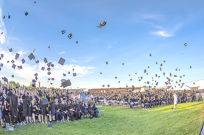 Douglas High School graduates toss their mortarboards in the air on Friday evening at the school.