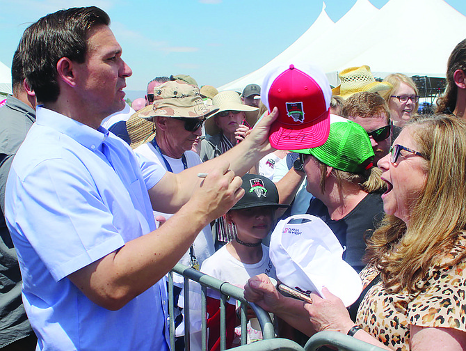 After his speech, Florida Gov. Ron DeSantis autographs a hat on Saturday at the eighth annual Basque Fry..