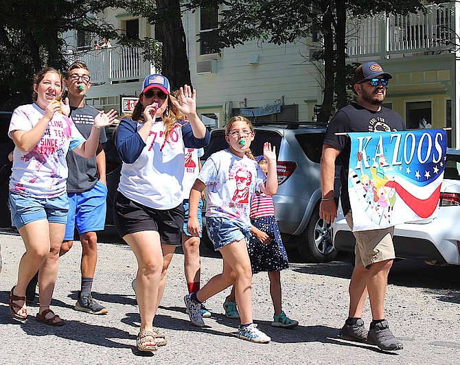 The kazoo players march down Nixon Street in Genoa on Tuesday morning in celebration of the Fourth of July.
