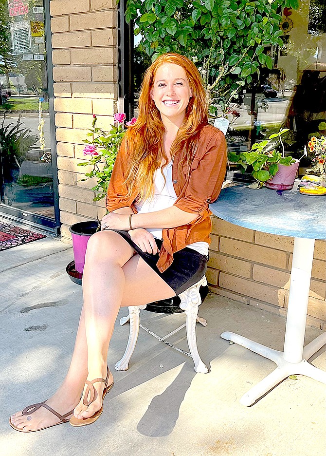 In Full Bloom owner Megan Jaramillo sitting in front of her new flower shop in the Gardnerville Ranchos. Photo by Amy Roby