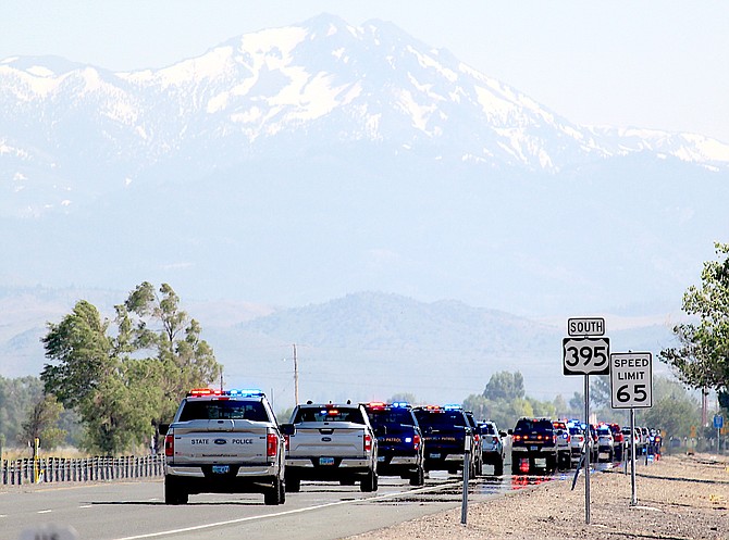 A procession escorting the family and remains of Nevada Highway Patrol Lt. Lorin Correll travels south on Highway 395 on Friday evening.