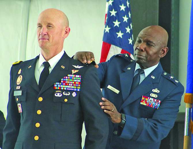 Maj. Gen. Ondra Berry, right, the state’s adjutant general, places a shoulder board on Brig. Gen. Dan Waters’ dress blue Army jacket during Friday’s promotion ceremony at the Nevada Army National Guard’s Army Aviation Support Facility.