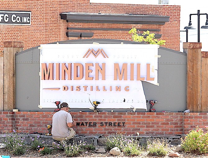 Sign workers put the final touches on the new Minden Mill Distilling sign at Highway 395 and Buckeye Road on Tuesday.
