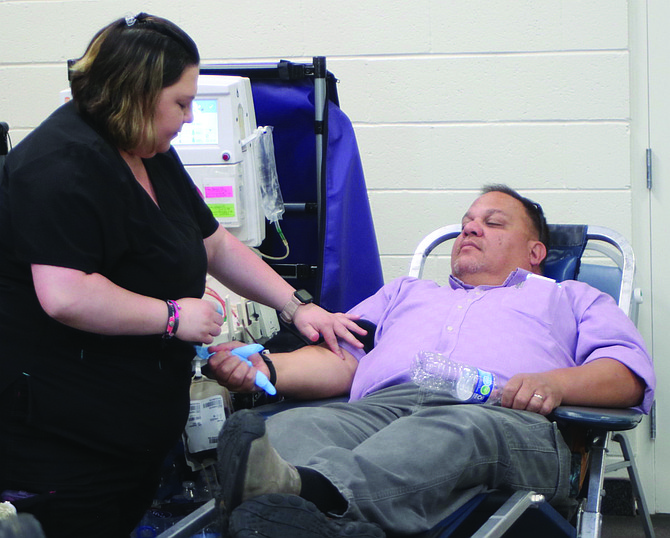 A Vitalant blood services technician prepares Churchill County Undersheriff Lee Orozco for donating blood during last week’s Battle of the Badges.