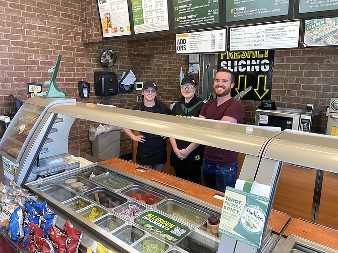 Subway employees Parker Procaccini, left, and Savanna Blair with new restaurant owner Levi Jenkins at the South Carson Street Subway on July 28.