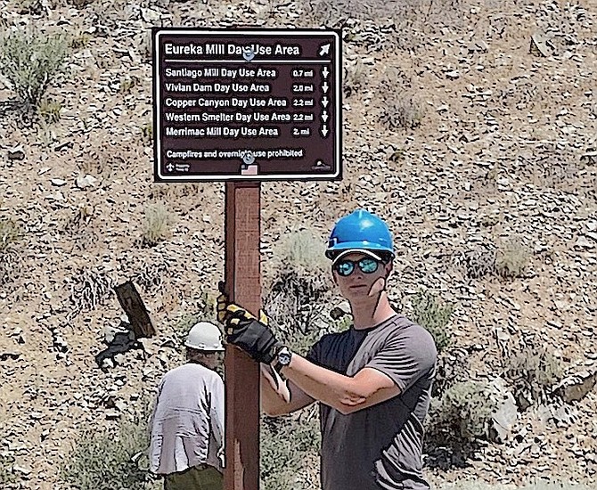 Chris Collins with one of the direction signs set up in mid July.