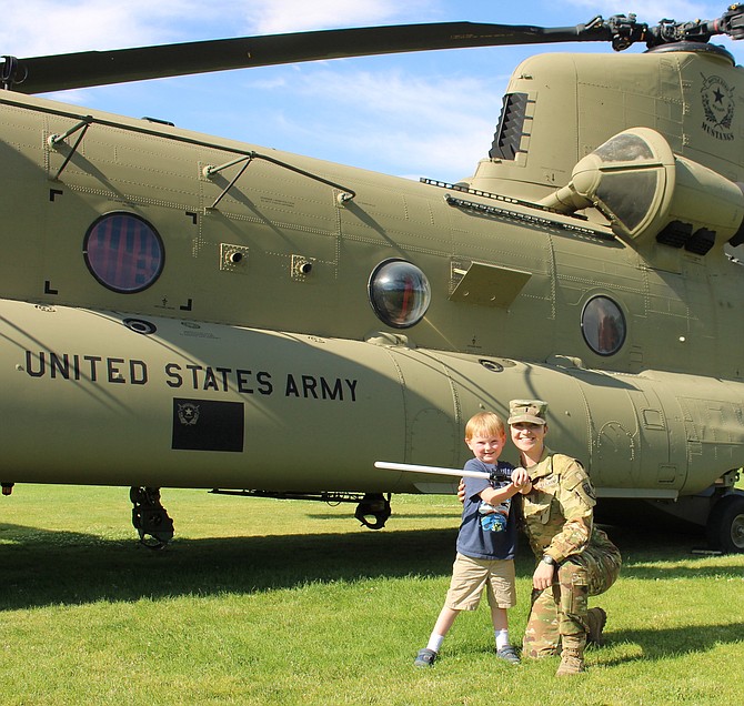 James King, 5, with Nevada Army National Guard 1st Lt. Hannah Fleming in front of a CH-47F helicopter at Mills Park for Sheriff’s Night Out on Aug. 1, 2023.