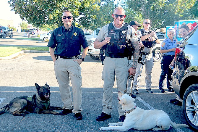 Deputy Dave Stanley and Zeke and Deputy Ryan Grant and Lagitha enjoy some shade during the National Night Out event at the Ironwood Center Tuesday. See them and other K-9 Units at Millennium Medical Spa during the fourth annual Pizza Pistols & Pooches event 1-4 p.m. today.