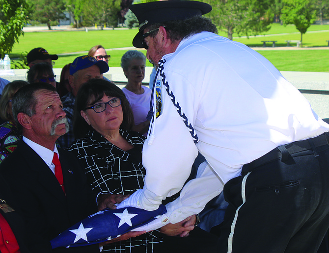 Nevada Veterans Coalition member David Rifkin presents the U.S. flag to Fernley Mayor Neal McIntyre. Looking on is Debbie Balsinger, constituent service representative for U.S. Rep. Mark Amodei.
