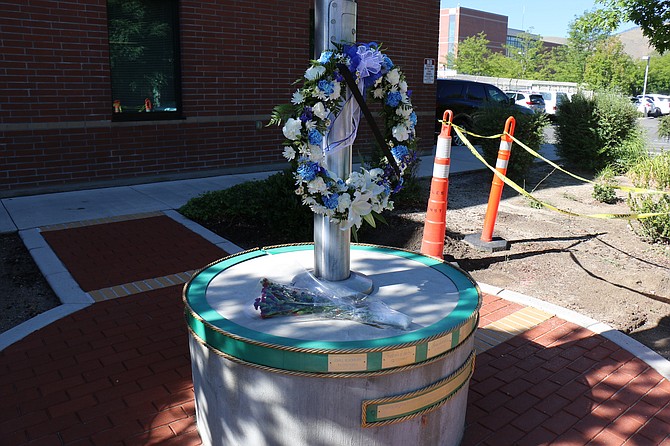 A wreath and flowers laid on the base of the flagpole outside the Carson City Sheriff’s Office on Tuesday in remembrance of Deputy Carl Howell, who died in the line of duty Aug. 15, 2015. Construction cones show the site of a future bench for quiet reflection on Howell and other deputies throughout CCSO history lost in the line of duty.