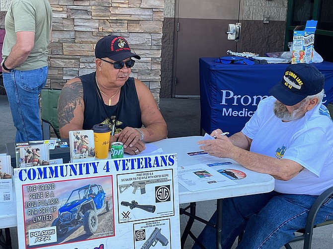 Marine veteran Frank Greenwood, left, sells a raffle ticket to another veteran earlier this month. His Cars & Stripes, a classic car celebration with funds benefiting military men, women and their families, is Saturday in Reno.