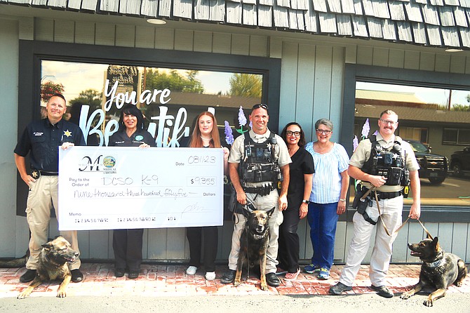 The Douglas County Sheriffs K-9 unit received a $9,350 check from Millennium Medical Spa Aug. 11which was fundraised during the fourth annual Pizza Pistols & Pooches event. From left, Sgt. Dave Stanley and Zeke, Pam Horton, Jesslyn Pendery, Deputy Adam Windsor and Beny, Amy Vidaurri, Gina Haase, Deputy Mark Brown and Riko.