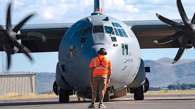 Dan Wilson, a fixed wing parking tender for the Bureau of Land Management, assists earlier in the week with launching an aerial firefighting aircrew aboard a Modular Airborne Fire Fighting System (MAFFS)-equipped C-130H assigned to the 153rd Airlift Wing at Klamath Falls Air Tanker Base, Oregon.