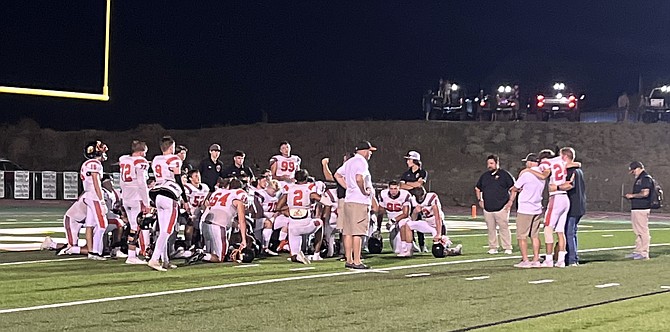 the Douglas High School football team gathers into a huddle after beating Argoaut, 40-0, to open the 2023 fall season.