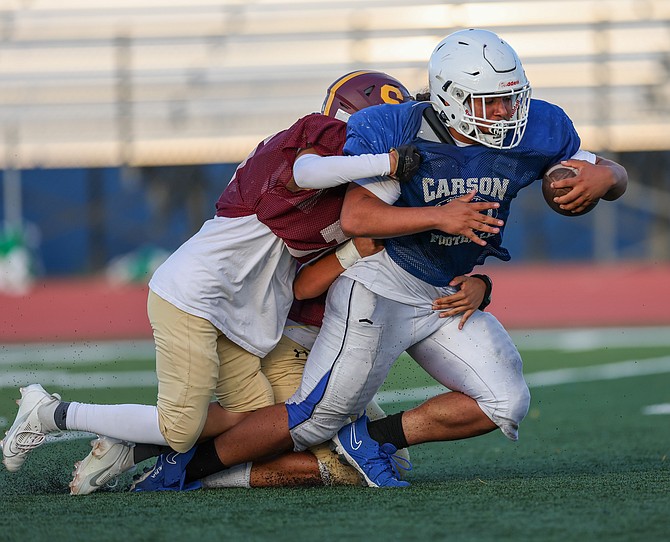 Angelo Macias drives for a few more yards during a preseason scrimmage at Carson High School.